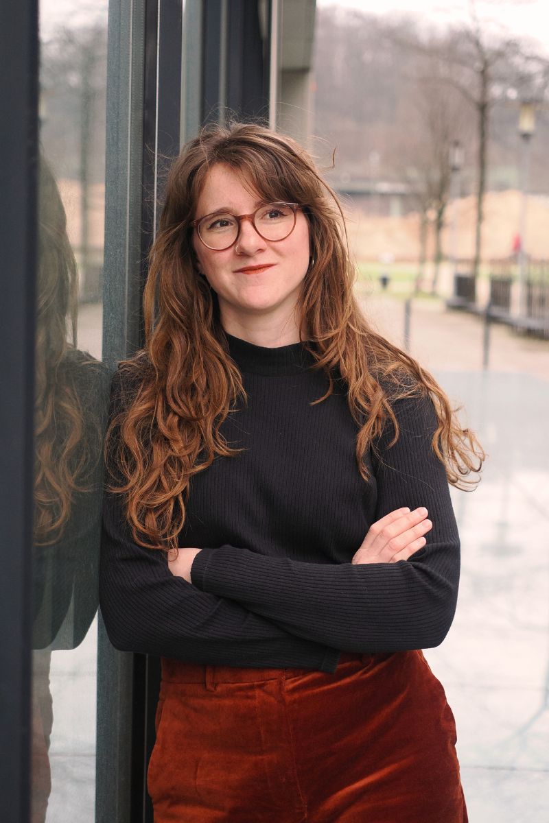 Lea Najork, angelehnt an eine Glaswand unter freiem Himmel